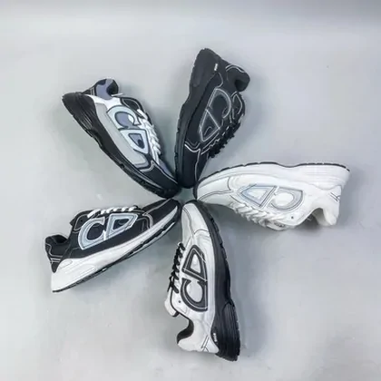 Four black and white sneakers arranged on grey fabric